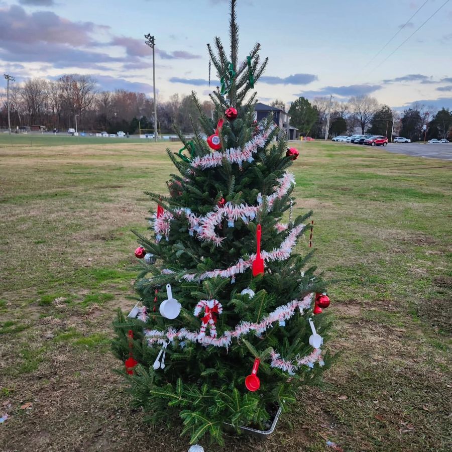 Outdoor Christmas tree decorated with measuring cups, spatulas and red ornaments