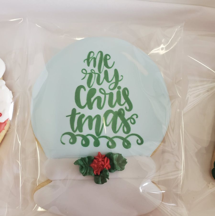 Snow globe sugar cookie with Merry Christmas lettering and poinsettia