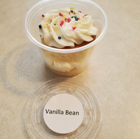 Vanilla bean cake cup layered with buttercream and rainbow sprinkles